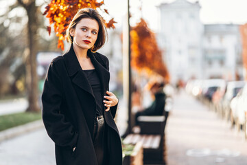 Young woman with short haircut and red lips strolling through the streets of the city