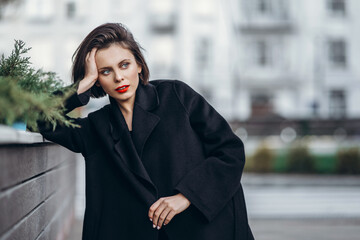 Obraz premium Close up portrait of young woman with short haircut and red lips outdoors