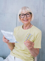 old woman in glasses reading medicine (pills) instruction. Age, health care, treatment concept