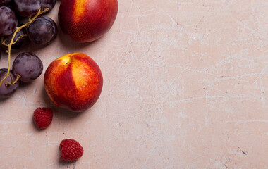 Copy space with nectarines and raspberry on pink concrete background