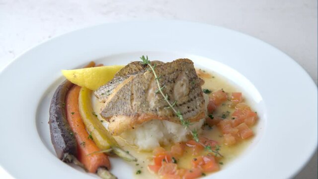 chef garnishing  seabass poele plate 