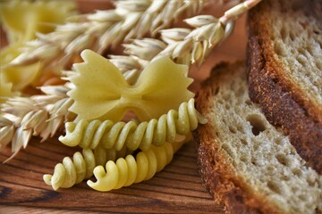Obraz na płótnie Canvas baked wheat bread, ears of wheat and pasta