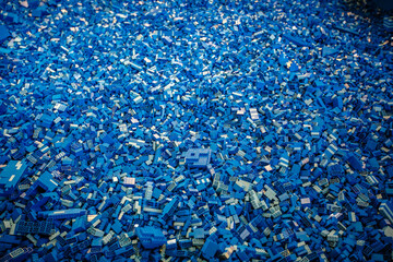 Pile of blue color building blocks with selective focus and highlight on one particular block using...
