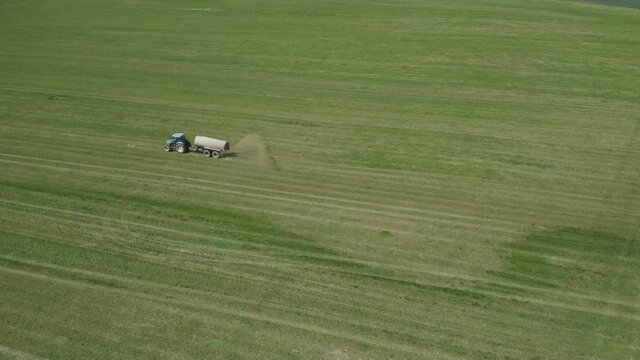 Aerial view of farming tractor. Natural eko fertilizer with manure.  Trailer fertilizes a freshly plowed agriculural.