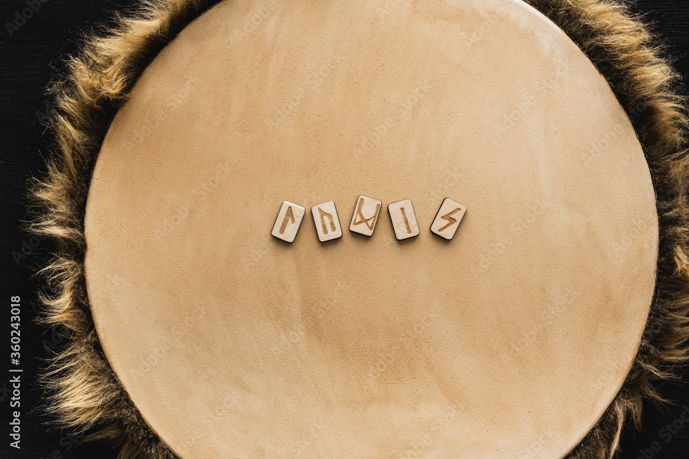 Poster top view of old runes on wooden surface