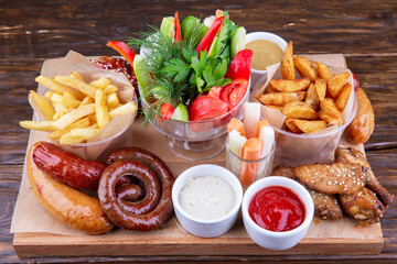 Set snack for beer from chicken wings, sausages, fries with ketchup