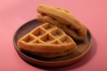 Two waffles on a pink background