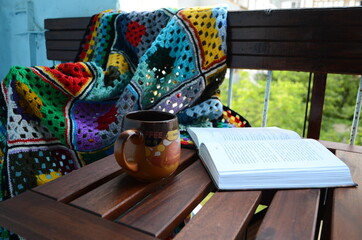 A cup of coffee, a book, and colored wrap.