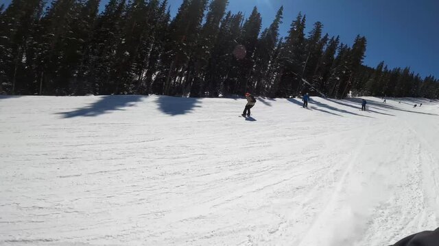 ACTION FOOTAGE : snowboarder riding fast and though skier traffic at the resort