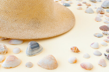 Beautiful straw hat with shells on the ocean coast. Nature summer background.