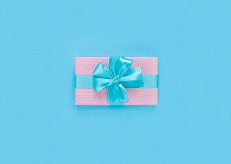 Pink gift box with bow and ribbon on paper background with empty place for text.