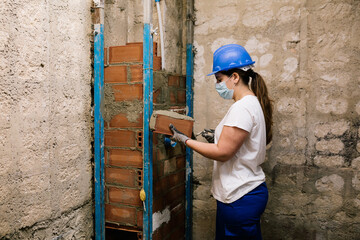 Obraz na płótnie Canvas woman with a mask working on a house renovation 