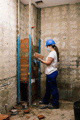 Obraz na płótnie Canvas woman with mask working on the construction of a bathroom