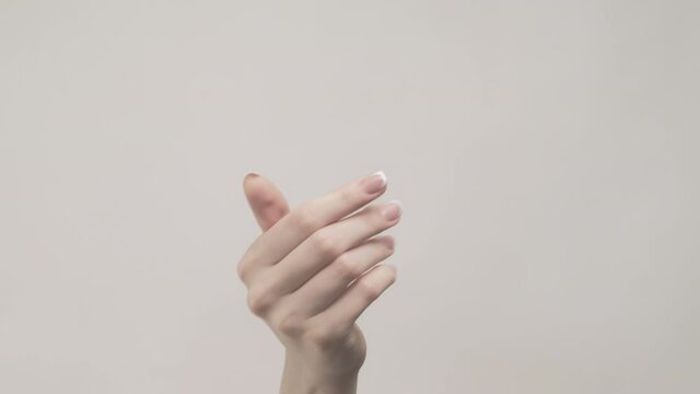 Hand gesture. Welcome signal. Woman fingers inviting to visit isolated on gray empty space background.