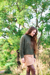 Fototapeta premium Girl in warm sweater on background of autumn trees