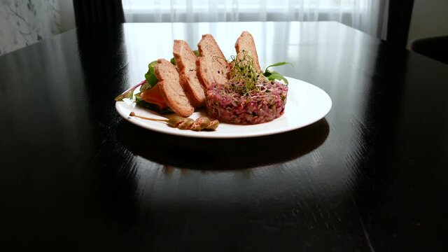 Raw tartar meat with spices, croutons and herbs. Beef tartar with capers. Beef tartar with slices of bread.  Raw meat tartare for gourmet meat.
