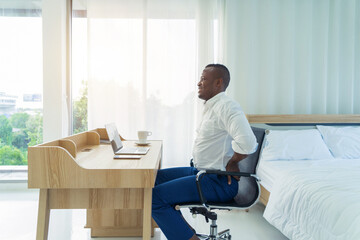 Tired business black american man, African person suffering from backache or cramp, working with...