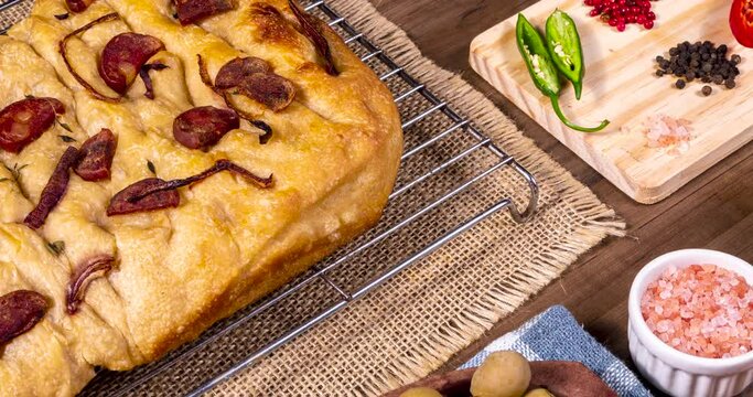 Traditional Italian Focaccia with pepperoni, cherry tomatoes, black olives, rosemary ando onion - homemade flat bread focaccia