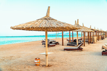 A beautiful beach with rustic bamboo umbrellas and a crystal clear sea