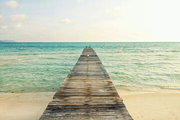 Minimalist landscape photo of a wooden pier against the vast blue sea in Koh Rong Island in Cambodia