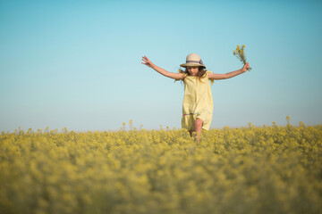 portrait of a beautiful teenage girl in a hat in a yellow field against the sky