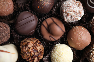 Different tasty chocolate candies as background, top view