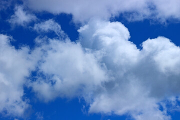 Obraz premium Awe background with bright blue sky and white fluffy clouds