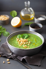 green creamy cauliflower spinach soup on gray background