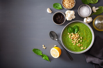 green creamy cauliflower spinach soup on gray background