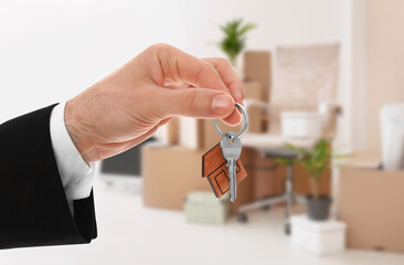 Man with key in new modern apartment, closeup