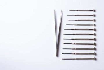 small parts and tweezers lie on a plain white background