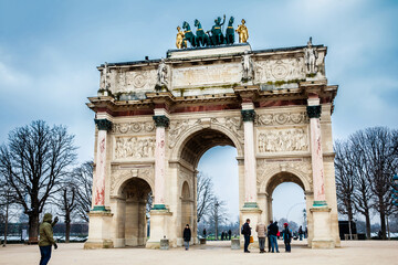 Fototapeta na wymiar Tourists at the Arch of Triumph in a freezing winter day just before spring