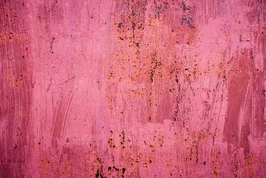 The old iron background is painted in red, pink, purple with rust and chips. © Maxim