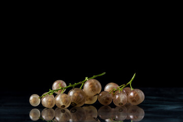 White currants on a black background. A small handful of white currant