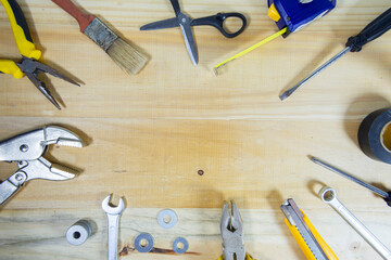 Working instruments scattered on a wooden surface with space for text in the center