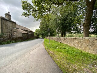 Rural road, with old buildings and dry stone walls near, Skipton, Yorkshire, UK