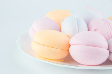 colorful marshmallows and chocolate cookies on a plate, isolate