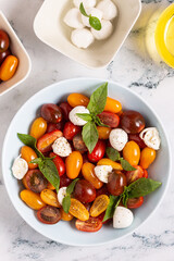 Italian caprese salad with tomatoes, mozzarella cheese, basil, olive oil.