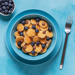 Trendy breakfast with mini pancakes, blueberries and chocolate chips.
