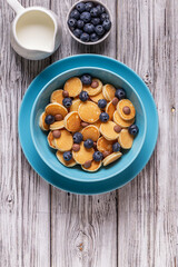 Trendy breakfast with mini pancakes, blueberries and chocolate chips.