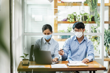 Coronavirus concept , Office workers wearing mask working together with infection protect.