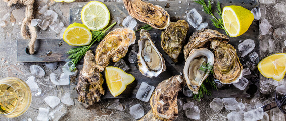 top view of delicious oysters on ice cubes and wine glass