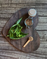 basil with spices on a dark wooden board