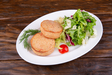 Fish cutlets with lettuce leaves and tomatoes