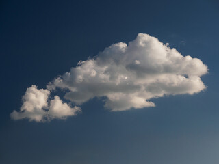 A white cloud against a dark blue sky.