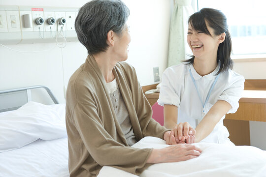 年配患者と話す看護師