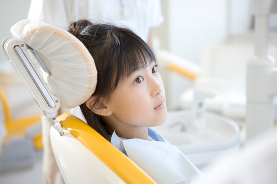 歯科医院の診察台に座る少女