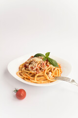 Italian pasta with tomato sauce and parmesan  in the plate on the white background. Copy space. Location vertical.