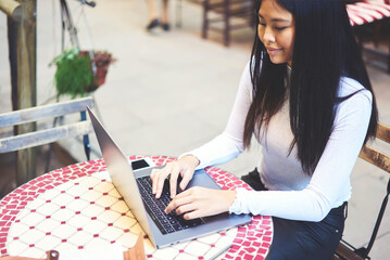 Cropped image young cute hipster girl watching funny video on computer using modern technology and...