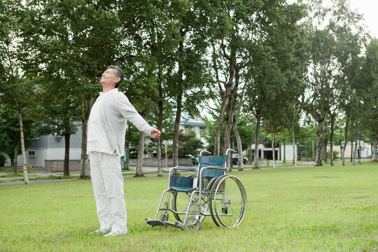 車椅子から立ち上がる60代の男性